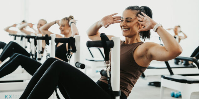 women on reformer bed performing a sit up